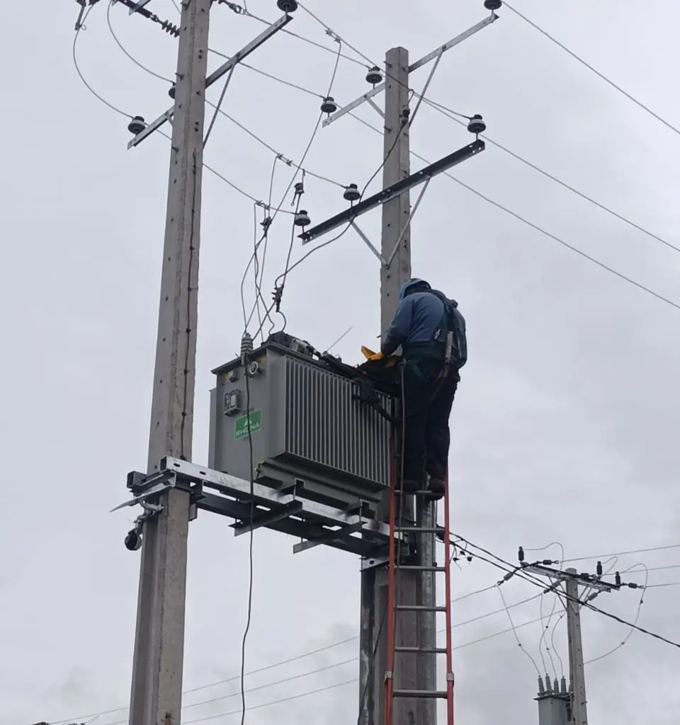 Técnico de GET Energy conectando un transformador montado en poste