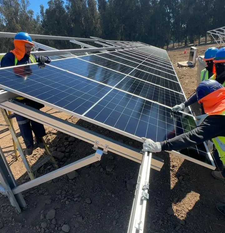 Equipo instalando módulos fotovoltaicos sobre estructuras en una planta solar